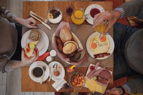 A breakfast table with various food items, utensils, and a coffee cup. - Hotel Residenz Passau (Passau)