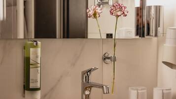 A bathroom with a granite countertop, a sink, a mirror, and a towel rack.