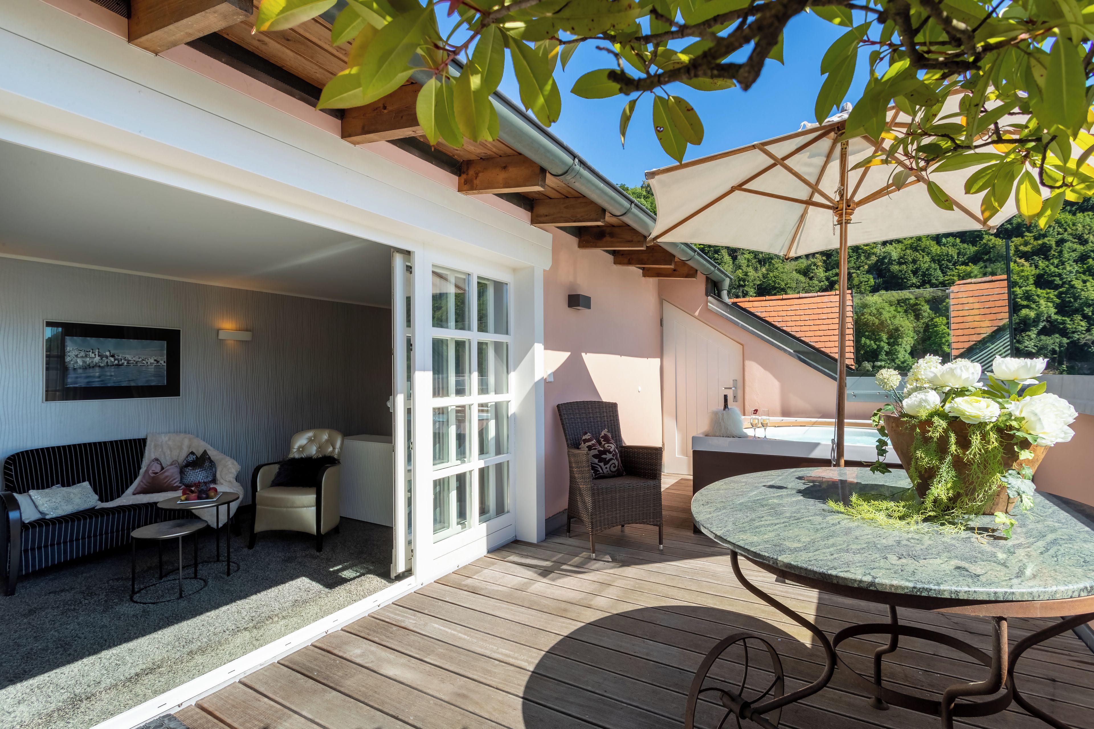 An outdoor patio with a table, chairs, and a covered seating area.