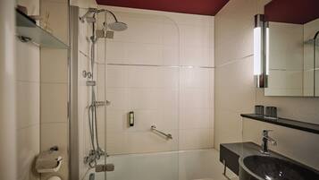 A modern bathroom with a glass-enclosed shower, a bathtub, a vanity with a sink, and a mirror above the sink.