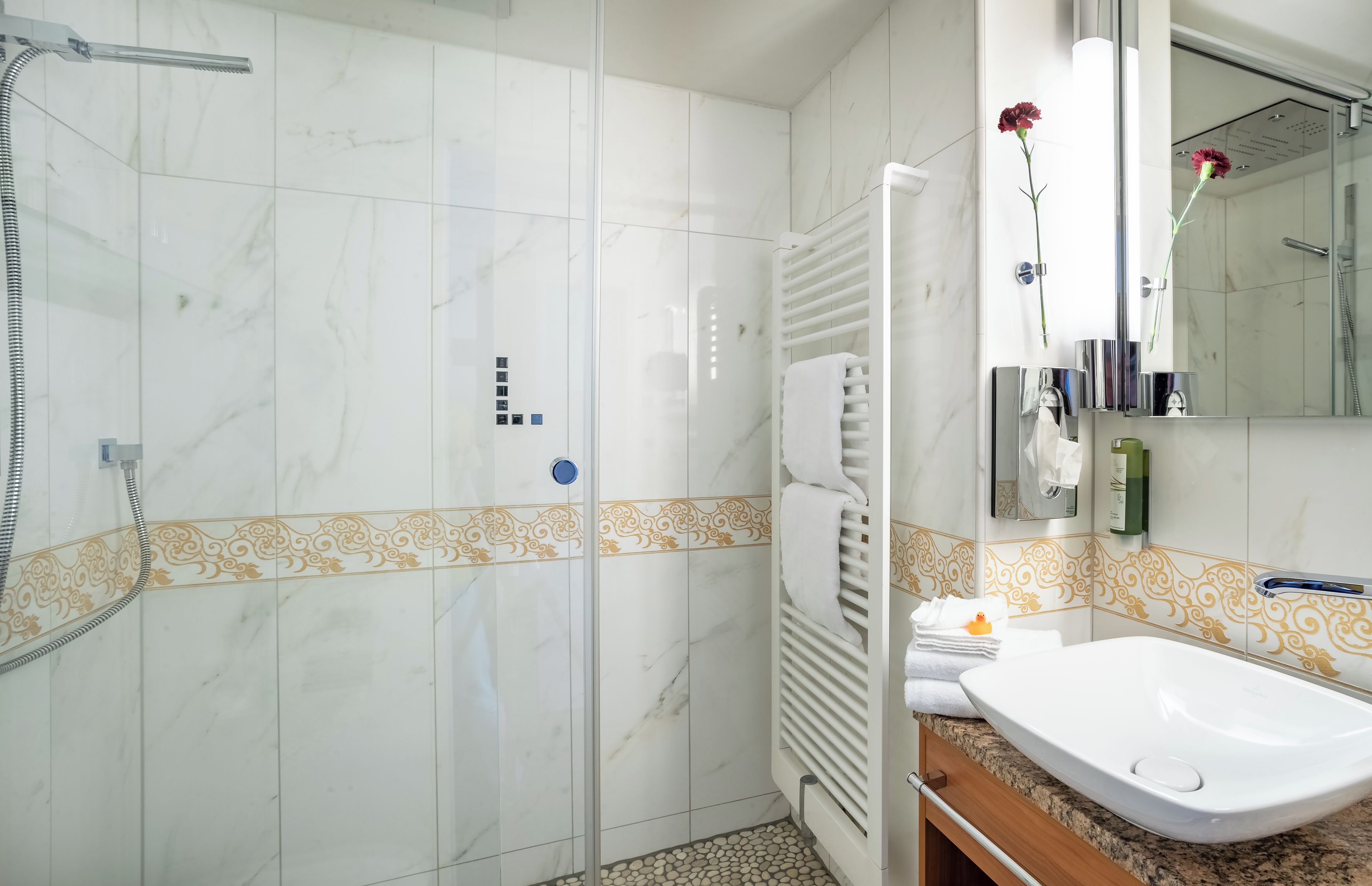 Ein Badezimmer mit Dusche, Waschbecken und Spiegel.