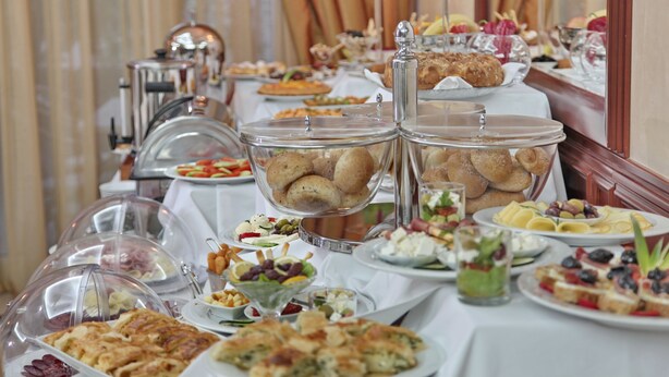 A buffet table with various food items and a coffee machine. - Hotel Orasac (Belgrade)