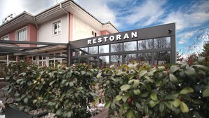 A hotel entrance with a sign reading "RESTORAN" and a covered walkway. - Hotel Orasac (Belgrade)