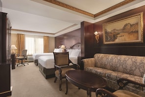 A hotel room with a king-sized bed, a sofa, a desk, and a chair. There is a painting on the wall and a window with curtains. - Radisson Hotel Toronto Airport West (Mississauga)