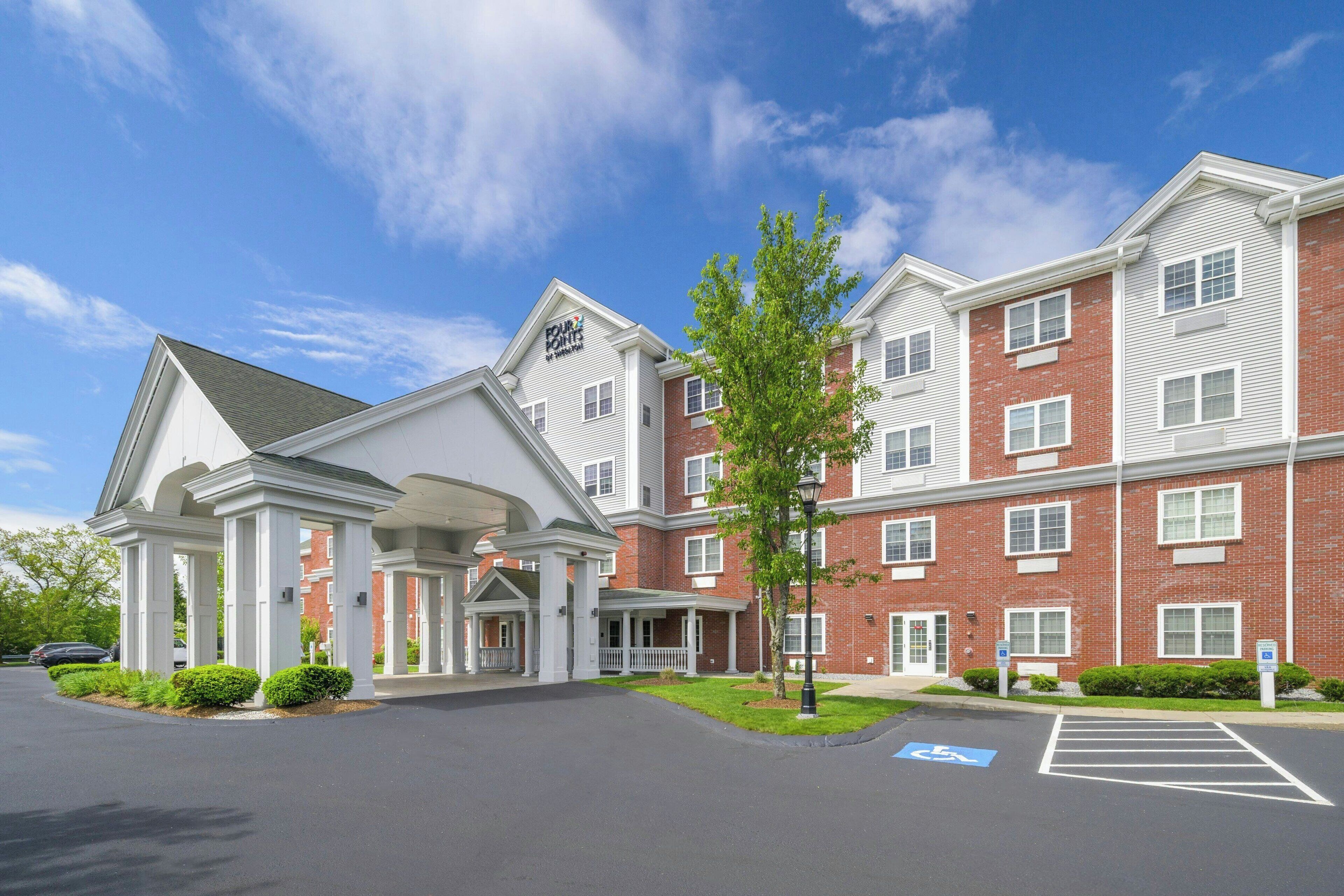 A multi-story hotel with a brick facade and white trim.