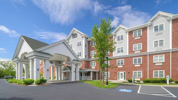 A multi-story hotel with a brick facade and white trim.