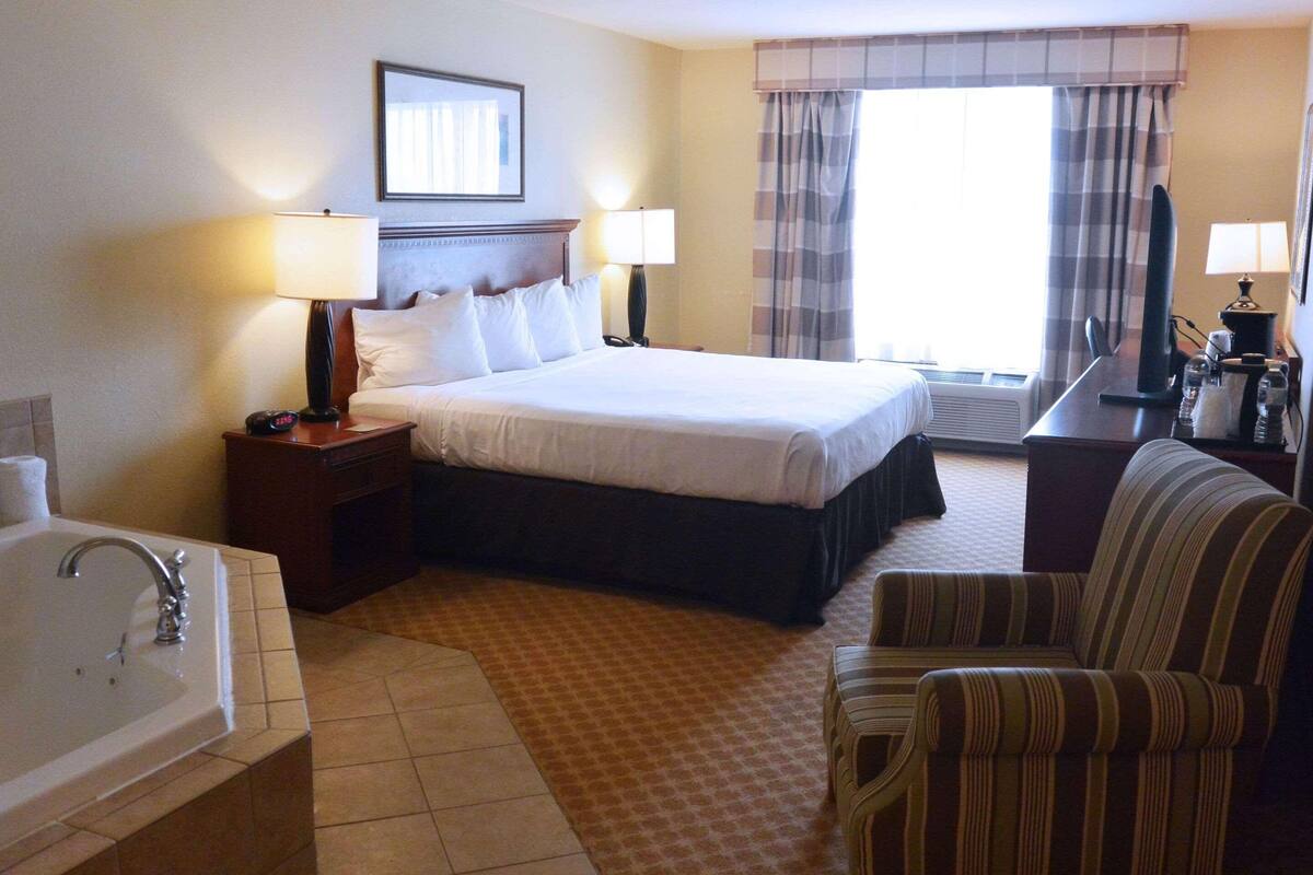 Suite, 1 King Bed, Non Smoking, Jetted Tub | Desk, laptop workspace, blackout curtains, iron/ironing board