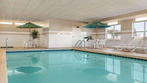 A swimming pool with lounge chairs and umbrellas, a tiled floor, and a door leading to another room. - Country Inn & Suites by Radisson, Peoria North, IL (Peoria)