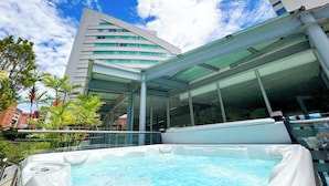 Un edificio moderno con fachada de vidrio y un jacuzzi al frente.