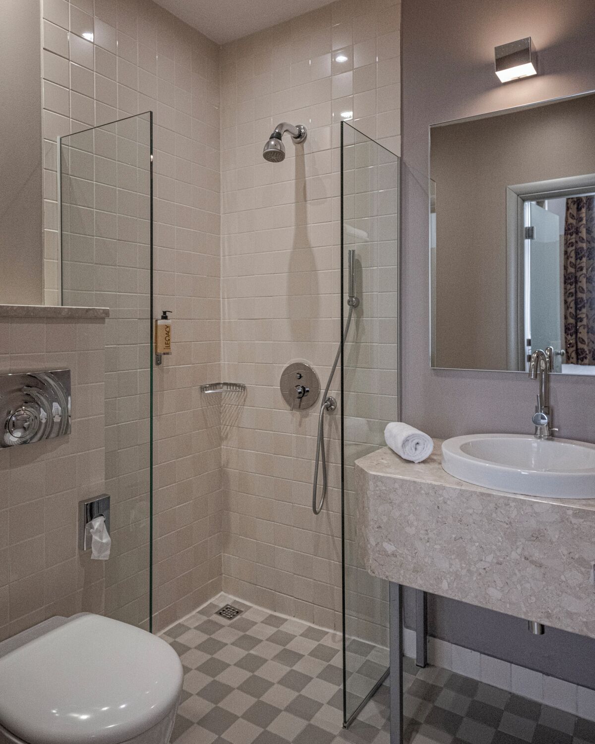 Un bagno moderno con cabina doccia in vetro, lavabo bianco e water.