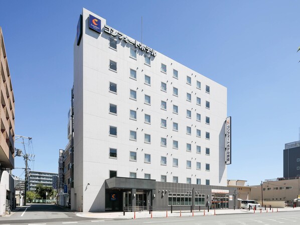 Un hotel moderno con fachada plana, múltiples ventanas y un llamativo letrero Comfort Hotel.