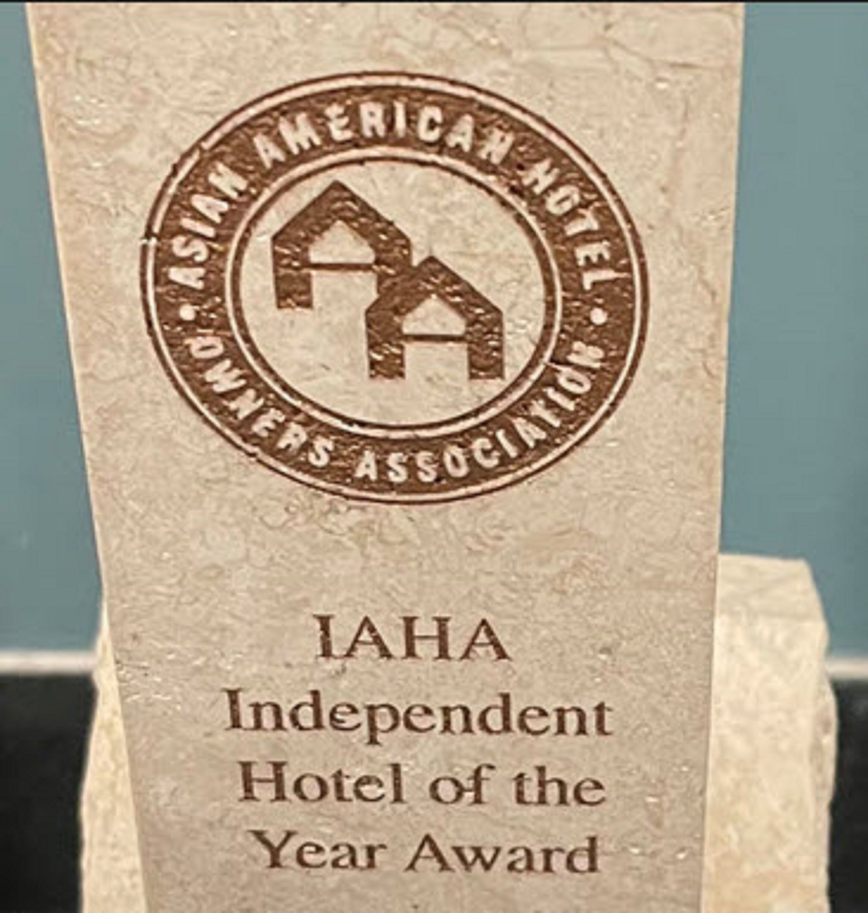A plaque with the text "IAHA Independent Hotel of the Year Award" and a logo of a house with a roof.