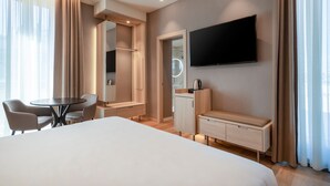 A modern hotel room with a large bed, a desk with a chair, a TV mounted on the wall, and a vanity with a mirror. - AC Hotel by Marriott Clodio Roma (Rome)