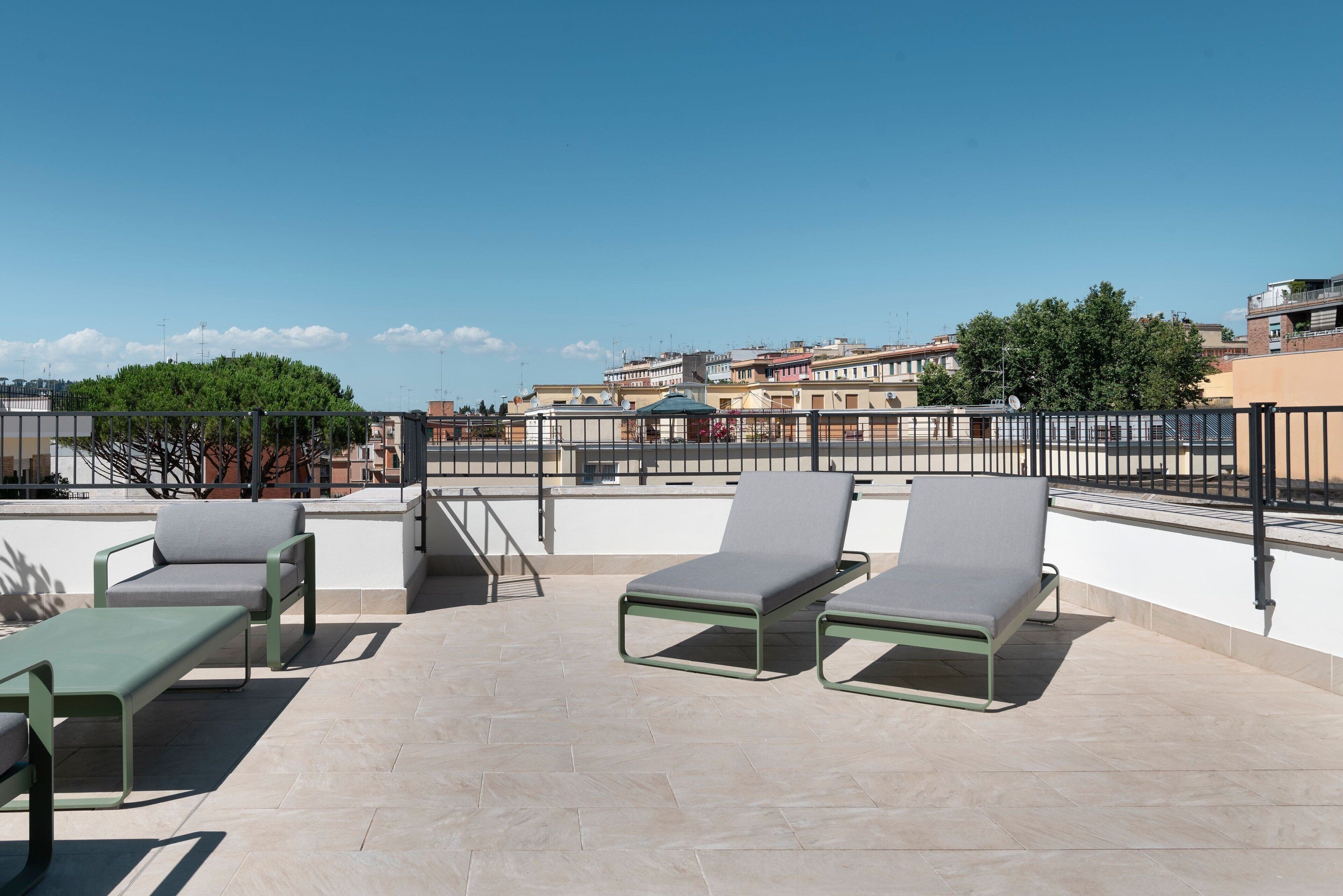 A rooftop terrace with outdoor seating and a view of the cityscape.