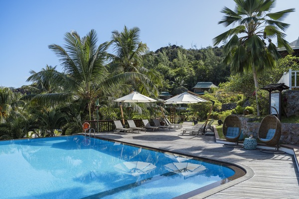 Alberca al aire libre, sombrillas en la alberca y camastros