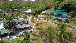A resort with multiple buildings, a paved walkway, and lush greenery. - Hotel L'Archipel (Praslin Island)