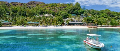 Na praia, areia branca, espreguiçadeiras, toalhas de praia