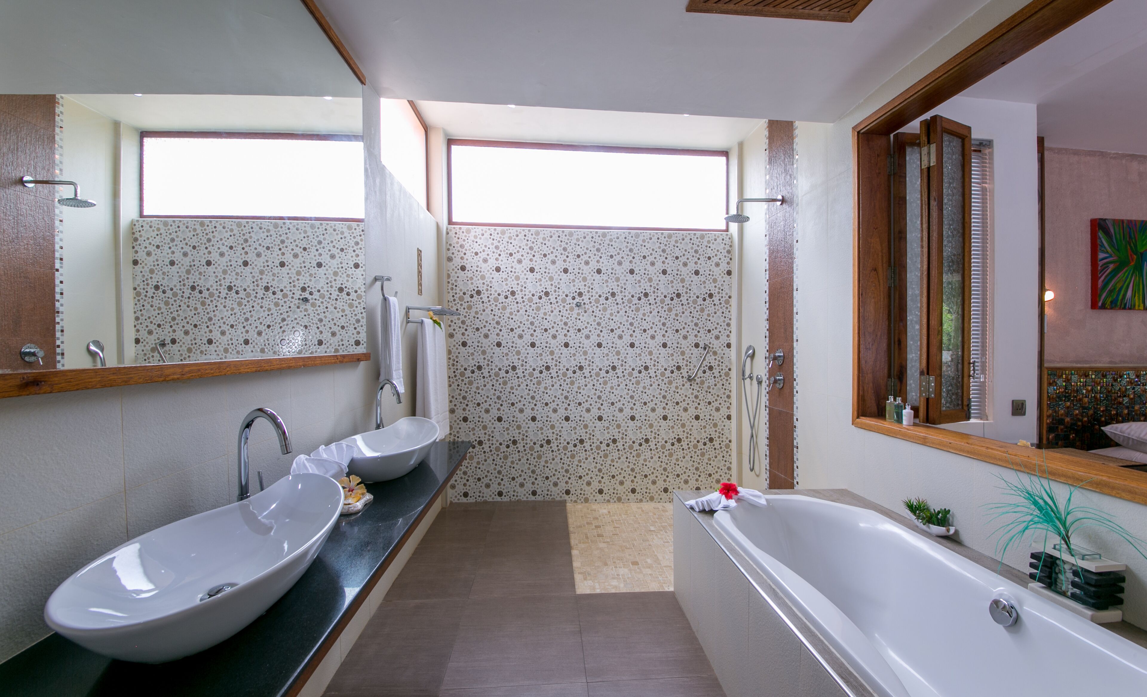 Ein modernes Badezimmer mit zwei Waschbecken, einer Badewanne und einer Dusche.