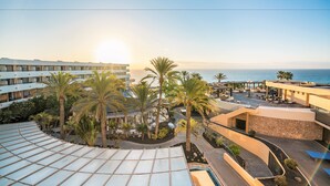 A resort with a pool, palm trees, and a view of the ocean. - Iberostar Waves Playa Gaviotas -All Inclusive (Pajara)