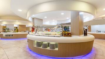 Een moderne buffetopstelling met een centraal bedieningspunt, diverse themastations en een ruime selectie dranken.