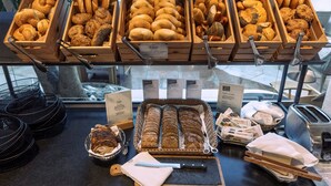 Een bakkerijdisplay met verschillende broden en gebak.