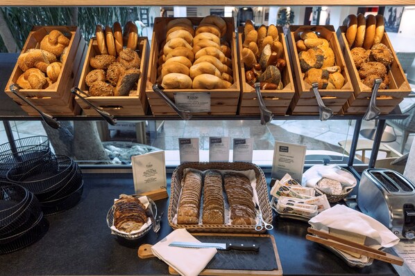Una vitrina de panadería con panes y pasteles varios.
