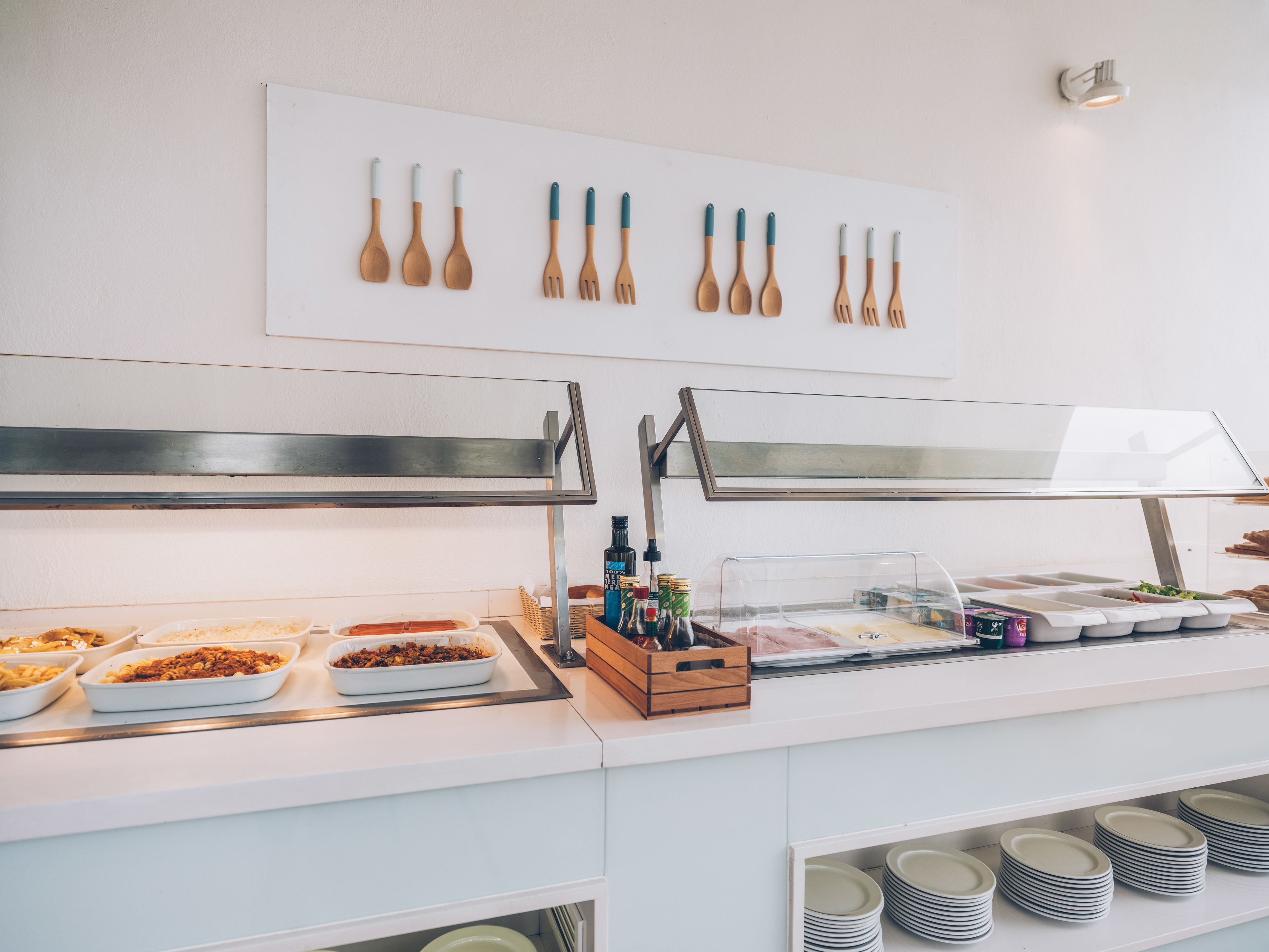 A buffet setup with various dishes, a spoon rack, and a bottle holder.