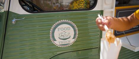 Un camion-restaurant vert dont le logo porte l’inscription « FOOD TRUCK ».