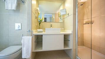 A modern bathroom with a toilet, sink, and shower.