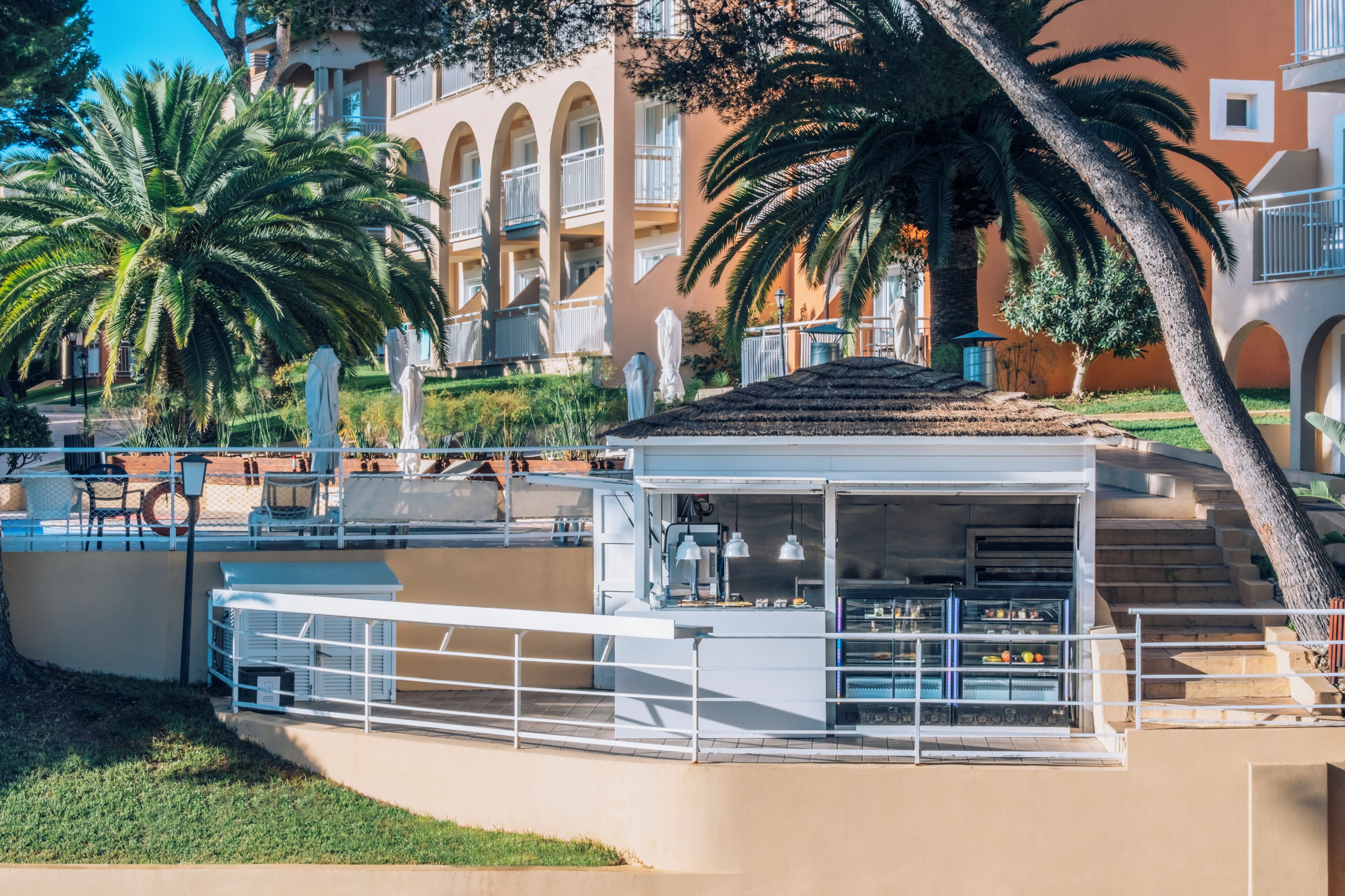 A coastal hotel with a pool area, outdoor seating, and a restaurant.