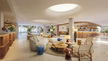 Un vestíbulo amplio con zona de bar, asientos y vistas al exterior.