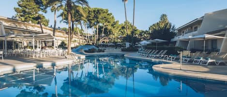 Una piscina al aire libre, sombrillas, tumbonas