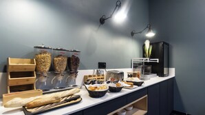 A breakfast buffet with various food items, a toaster, and a coffee machine. - City Residence Ivry (Ivry-sur-Seine)