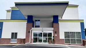 A modern building with a flat roof, a central entrance with glass doors, and a brick facade. - Comfort Inn & Suites Brunswick I-95 (Brunswick)