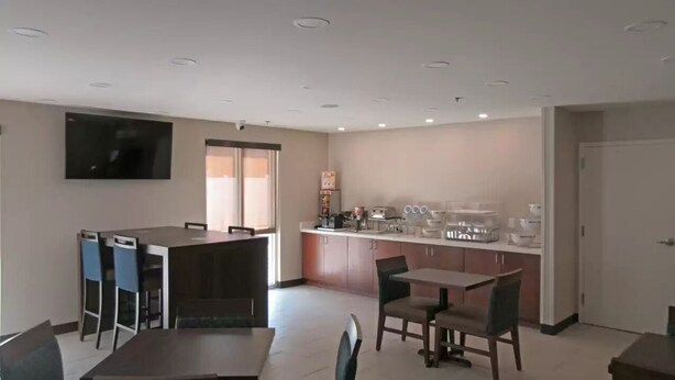 A modern hotel room with a dining area, a kitchen, a flat-screen TV, and a large window. - Comfort Inn & Suites Brunswick I-95 (Brunswick)