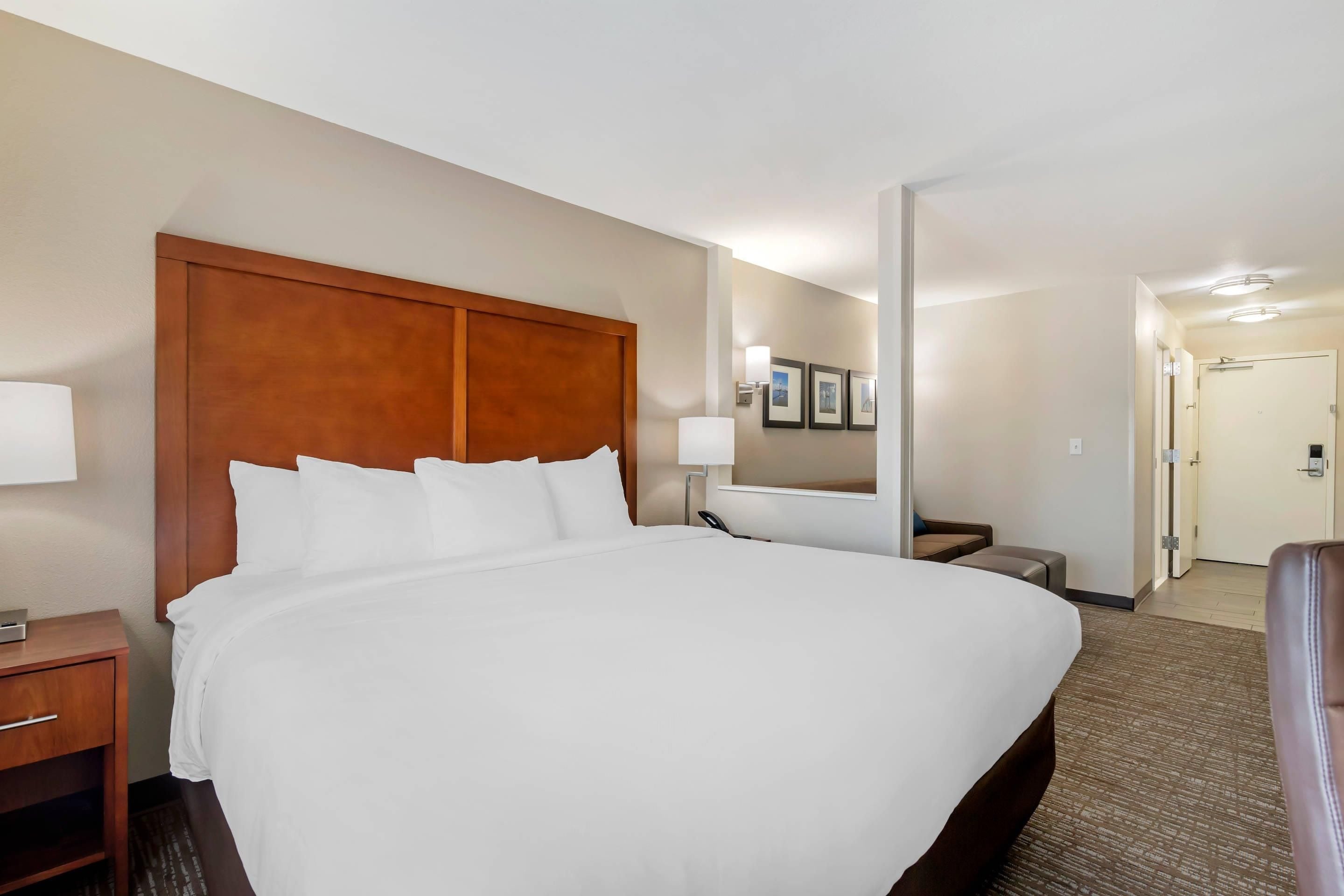 A hotel room with a large bed, bedside tables, a desk, and a chair.