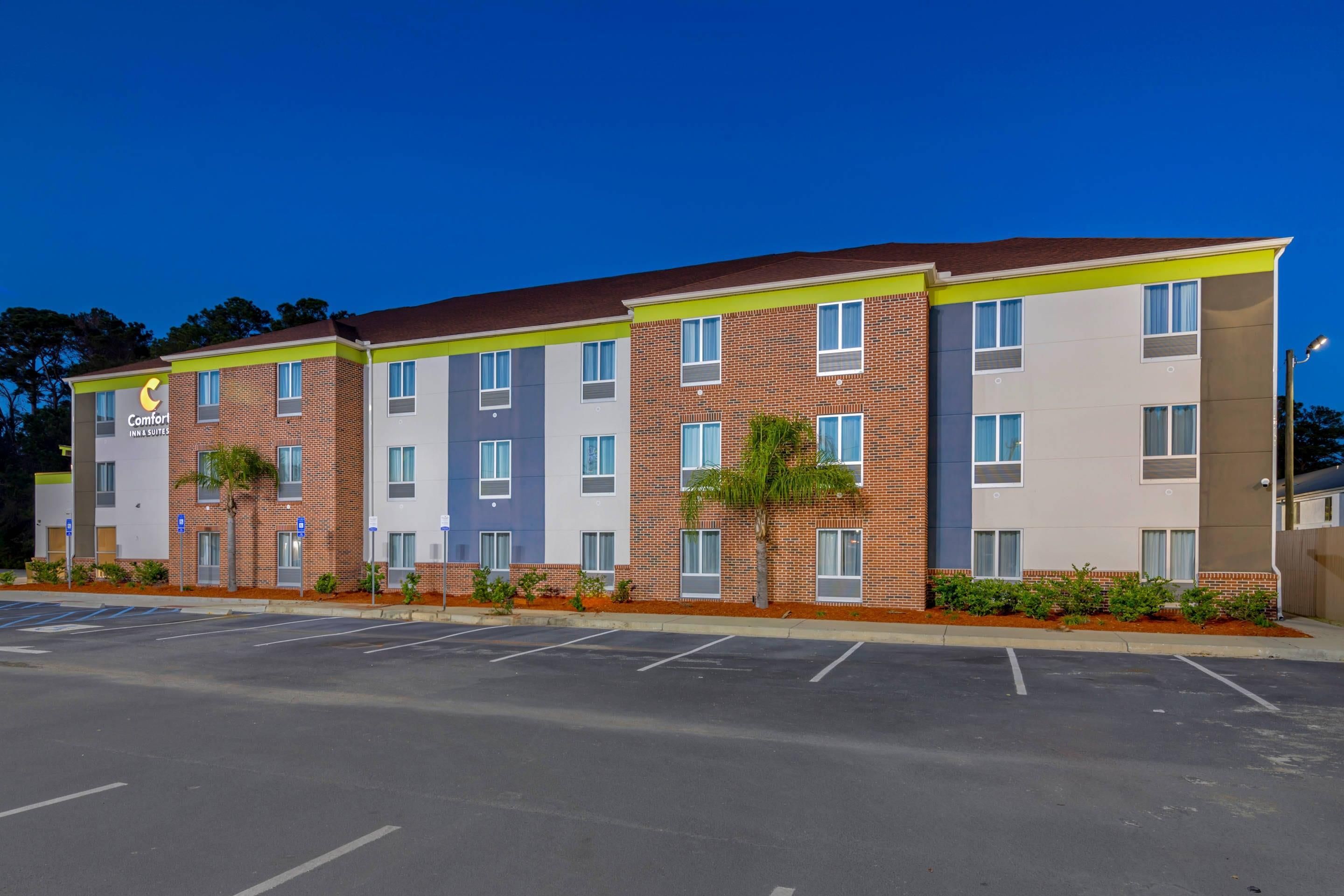 A multi-story hotel with a parking lot in front.