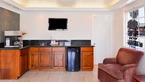 A modern kitchen with wooden cabinets, a black countertop, and a built-in dishwasher.