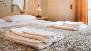 A neatly made bed with folded towels and a lamp on a bedside table in a hotel room. - Hotel Original (Turin)
