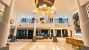 A spacious lobby with high ceilings, a central seating area, and a decorative light fixture. - Samaya Wellness Resort (Koh Samui)