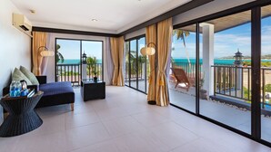 A spacious balcony with a view of the ocean, a comfortable seating area with a sofa and side table, and a large window with curtains. - Samaya Wellness Resort (Koh Samui)