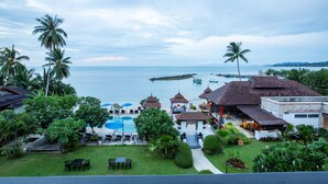 A resort with a pool, outdoor seating, and a view of the sea. - Samaya Wellness Resort (Koh Samui)