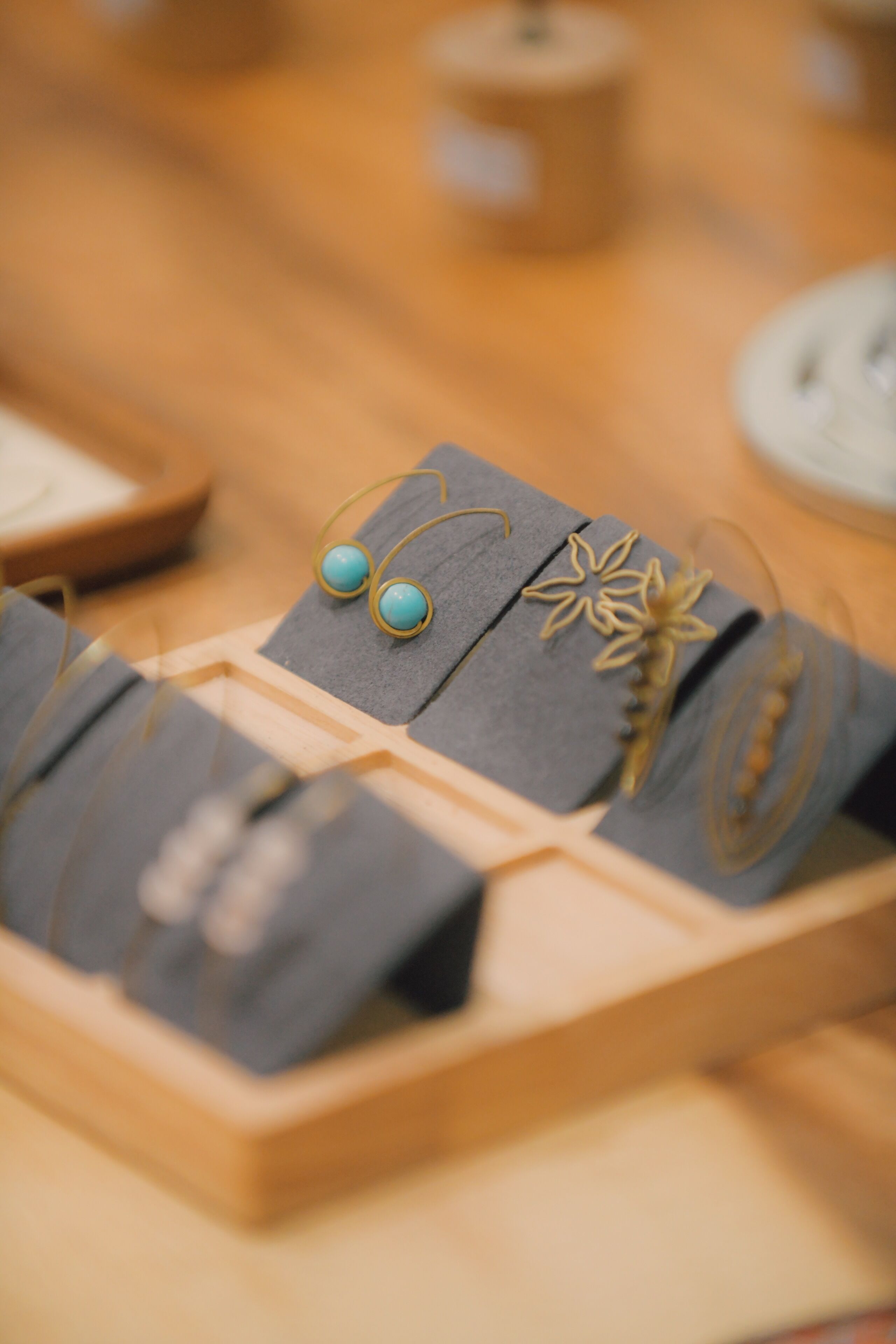 Una exhibición de joyería sobre un pedestal de madera, con un fondo desenfocado.