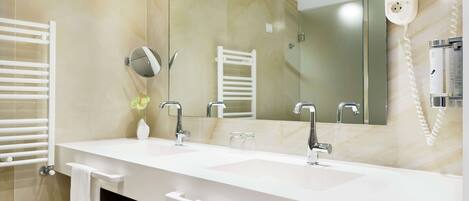 Un baño moderno con lavamanos doble, un espejo grande, un perchero para toallas y un secador de pelo.