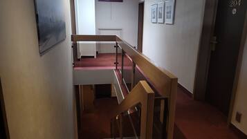 A multi-level interior with a staircase, a door labeled "204", and a red carpeted floor.