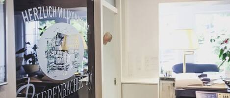 A reception area with a glass door displaying a welcome sign and a black and white illustration.
