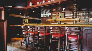 A bar area with wooden stools and a bar counter. - Hotel Bierenbacher Hof (Nümbrecht)
