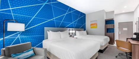 Una habitación de hotel con una cama grande, un escritorio, una silla y un sofá.