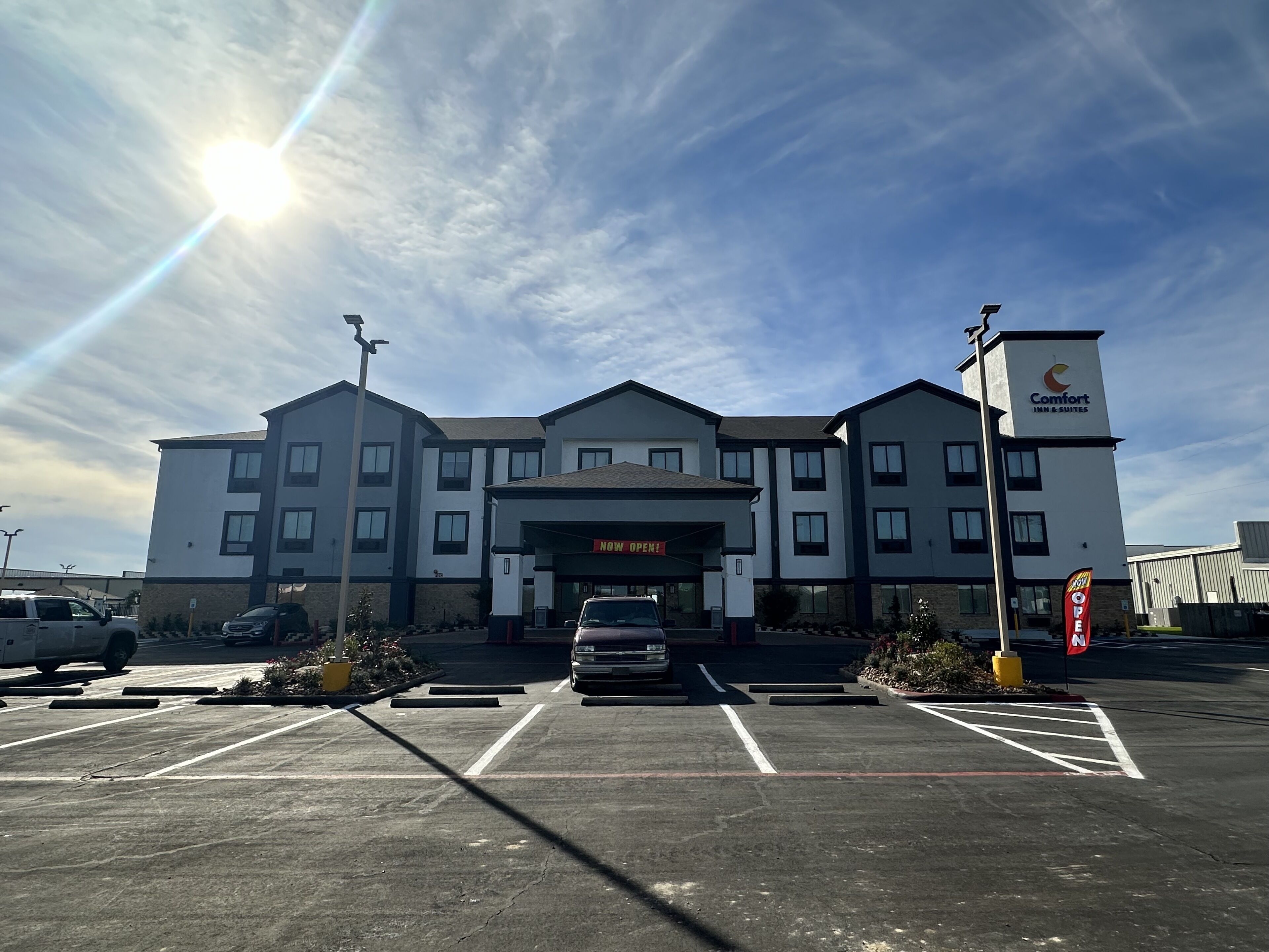 A Comfort Inn & Suites with a clear sky and parking lot.
