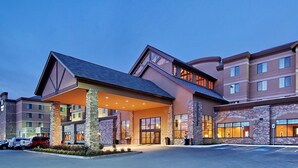 A multi-story hotel with a covered entrance, stone facade, and multiple windows. - Embassy Suites by Hilton Anchorage (Anchorage)
